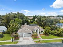 Expansive home with manicured lawn, mature trees, three-car garage and screened in pool at 3037 Crest Dr, Clearwater, FL 33759