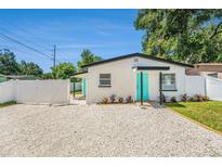 Charming home featuring a bright teal door and modern white gravel landscaping at 3617 E Louisiana Ave, Tampa, FL 33610