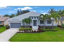 Beautiful exterior of a two-story home featuring manicured landscaping, a gray roof, and a gray two-car garage at 425 4Th N Ave, Tierra Verde, FL 33715