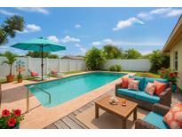 This backyard boasts a sparkling pool surrounded by lounge seating, perfect for relaxing and entertaining at 4906 N Arrawana Ave, Tampa, FL 33614
