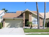 Charming single-story home with a two-car garage and a well-manicured front lawn at 5581 Greyston St, Palm Harbor, FL 34685