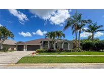 Charming single-story home features a well-manicured lawn, mature trees, and a spacious three-car garage at 10675 Park Place Dr, Largo, FL 33778