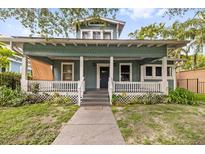Charming two-story home featuring a cozy front porch and well-maintained landscaping at 112 E Plymouth St, Tampa, FL 33603