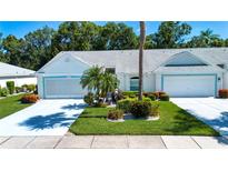 Charming single-story home featuring a two-car garage, lush landscaping, and a well-manicured lawn at 2019 Gardenia Landings Lane Ln, Sun City Center, FL 33573