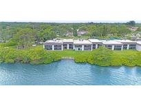 Waterfront condos offer scenic views, lush landscaping, and community amenities on a serene day at 2980 Haines Bayshore Rd # 105, Clearwater, FL 33760