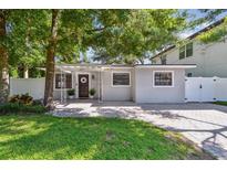 Charming single-story home featuring brick paved driveway, manicured lawn, and decorative door with a beautiful green wreath at 3127 W Oakellar Ave, Tampa, FL 33611