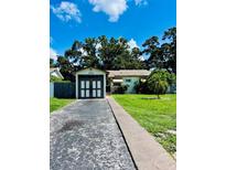 Charming single-story home featuring an attached garage and a well-maintained lawn, with mature trees in the background at 3135 33Rd N Ave, St Petersburg, FL 33713