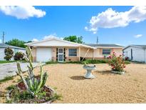 Charming single-story home with tidy gravel landscaping, small decorative plants and cheerful curb appeal at 4025 Chesswood Dr, Holiday, FL 34691