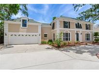 Stately two-story home featuring a green roof, shuttered windows, and a three-car garage at 4901 W Estrella St, Tampa, FL 33629