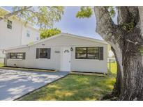 Charming single-story home with a well-maintained lawn and mature tree providing shade at 7516 S Obrien St, Tampa, FL 33616
