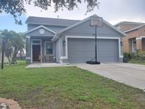 Charming single-story home with a gray exterior, well-manicured lawn, and a two-car garage at 10109 36Th E Ct, Parrish, FL 34219