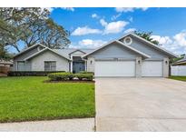 Charming single-story home featuring a three car garage, landscaped yard and freshly cut lawn at 134 Barrington Dr, Brandon, FL 33511