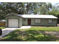 Charming single-story home featuring a one-car garage, metal roof, and freshly cut lawn at 208 Wilson Ave, Brooksville, FL 34601