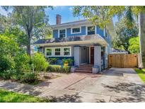 Charming two-story home featuring blue siding, brick accents, a red front door, and mature trees in a well-maintained yard at 304 21St N Ave, St Petersburg, FL 33704