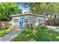 Charming home with a blue front door, landscaped garden, and inviting walkway at 4460 67Th N St, St Petersburg, FL 33709
