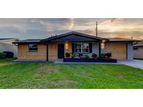 Charming single story home with wood and painted siding and a well maintained, green front yard at 7031 Magnolia Valley Dr, New Port Richey, FL 34653