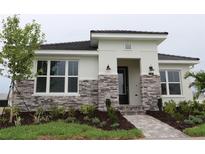 A modern home with a stone facade, and lush landscaping leading to the welcoming front door at 719 Allora Ave, Nokomis, FL 34275