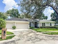 Charming single-story home with well-manicured lawn, mature trees, and a three-car garage at 11501 Norval Pl, Temple Terrace, FL 33617