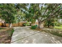 A long driveway leads to this charming home with stone accents and mature trees at 11783 102Nd Ave, Largo, FL 33778