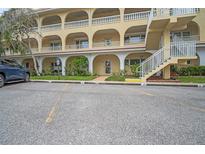 Condominium complex featuring covered parking, multiple floors, and exterior stairway at 2222 Norwegian Dr # 16, Clearwater, FL 33763