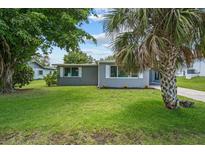 Charming single-story home with a well-manicured lawn, mature trees, and inviting curb appeal at 2701 Camellia Ter, Punta Gorda, FL 33950