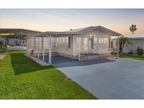 Charming single-story home with a covered porch, well-maintained lawn, and paved driveway at 35045 Cynthia Ave # 35945, Zephyrhills, FL 33541