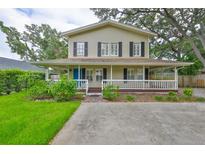 Charming two-story home featuring a welcoming wrap-around porch and nicely landscaped front yard at 3906 W San Luis St, Tampa, FL 33629