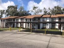 Condominium building featuring covered parking and well-maintained landscaping at 39132 County Road 54 Rd # G 2164, Zephyrhills, FL 33542