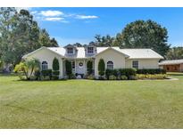 Charming single-story home with a manicured lawn and lush landscaping, creating inviting curb appeal at 4312 James L Redman Pkwy, Plant City, FL 33567