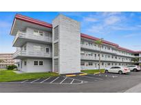 Exterior view of a three story condo building with a red roof and multiple balconies at 5660 80Th N St # B106, St Petersburg, FL 33709