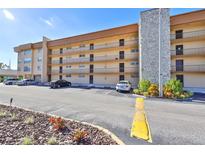 Multi-story condo building with parking and a stone pillar at 5820 N Church Ave # 147, Tampa, FL 33614