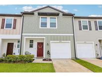 Charming townhome with attached garage, neutral siding, and well-maintained front lawn at 6235 Bucket Ct, Gibsonton, FL 33534