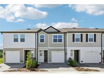 New townhomes show modern exteriors with driveways and landscaping under a sunny sky at 7678 Deer Valley Circle, Tampa, FL 33635