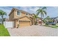 Two-story home showcasing a neutral color scheme, two-car garage, a paver driveway and mature landscaping at 1205 Sweet Gum Dr, Brandon, FL 33511