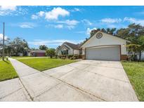 Charming one-story home boasts a well-manicured lawn, a two-car garage, and appealing architectural details at 12405 Pathway Ct, Riverview, FL 33569