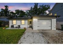 Charming home featuring a well-manicured lawn, textured exterior, and cozy front patio seating at 206 N Beverly Ave # 1/2, Tampa, FL 33609