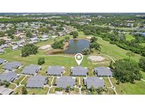 This aerial view showcases a well-maintained community with lush landscaping and serene pond views at 301 Canton Ct # 77, Sun City Center, FL 33573