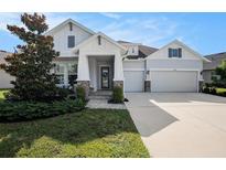 Charming home featuring a three-car garage, stone accents, and manicured landscaping for great curb appeal at 3603 Tour Trce, Land O Lakes, FL 34638