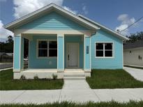 Charming single-story home with a delightful blue exterior and freshly cut lawn at 4200 N 15Th St, Tampa, FL 33610