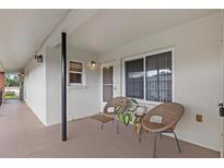 Cozy condo patio with neutral tones, two wicker chairs, and a charming plant on a small, wooden table at 4540 Overlook Ne Dr # 246, St Petersburg, FL 33703