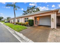 Charming single-story home with an attached garage, well-manicured lawn, and colorful landscaping at 8319 Annwood Rd, Seminole, FL 33777