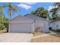 Charming single-story home featuring a two-car garage, landscaped yard, and traditional architectural details at 1004 Osage St, Clearwater, FL 33755