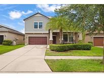 Charming two-story home featuring a well-manicured lawn and covered front porch at 11024 Purple Martin Blvd, Riverview, FL 33579