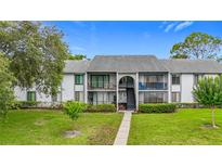 Inviting two-story condo with well-manicured lawn and access stairs to the upper units at 1207 Pine Ridge W Cir # H2, Tarpon Springs, FL 34688