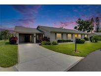 Charming single-story home with a well-manicured lawn, mature landscaping, and a covered carport at 123 Glendower Cir # 123, Sun City Center, FL 33573