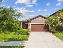 Inviting single-Gathering home featuring a well-maintained lawn and an attached two-car garage at 1325 Custer Bayou St, Ruskin, FL 33570