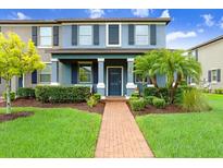 Charming two-story townhome featuring a well-manicured lawn and beautiful landscaping at 17378 Cruiser Bnd, Land O Lakes, FL 34638