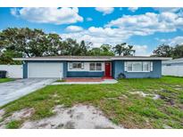 Charming single-story home with a well-manicured lawn and bright red door at 1800 Pine St, Clearwater, FL 33764
