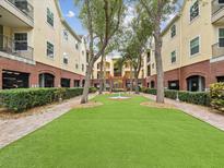 Beautiful courtyard featuring lush green space, manicured landscaping, and a charming water feature at 2010 E Palm Ave # 14303, Tampa, FL 33605
