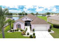 Charming single-story home with a well-manicured lawn, mature landscaping, and a lakeside view at 2226 N Creek Ct, Sun City Center, FL 33573